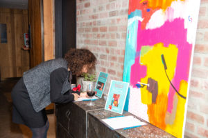 A woman with brown curly hair placing a silent auction bid.